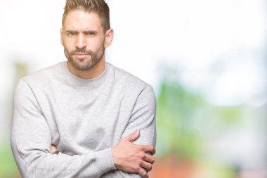 Genç yakışıklı adam izole arka plan şüpheci ve sinir, onaylamayan ifade yüz çapraz kollu kazak giyiyor. Negatif kişi.