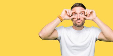 Yakışıklı adam rahat beyaz t-shirt giyen parmaklarıyla, uykulu ve sabah yorgunluk için yorgun gözlerini açmaya çalışıyor