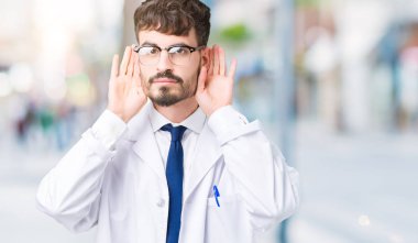 Her ikisi de dinliyoruz izole arka plan üzerinde Beyaz önlük giyen genç profesyonel bilim adam kulak jest, dedikodu için meraklı eller. İşitme sorunu, sağır