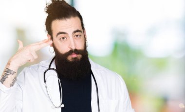 Doktor stetoskop tıbbi ceket giyen uzun saçlı çekim ve kendini el ve parmak işaret öldürme baş için intihar jest.