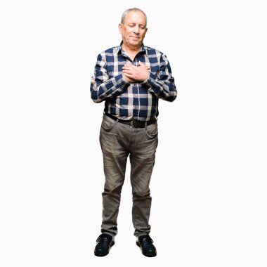 Göğüs kapalı gözler ve yüzünde minnettar jest ile rahat gömlek ile gülümseyen yakışıklı komuta sizde eller. Sağlık kavramı.