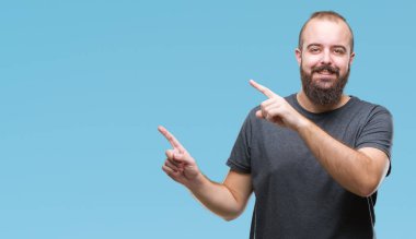 Genç beyaz hipster adam gülümseyerek ve iki elleri ve parmakları ile tarafına işaret kamera bakarak izole arka plan.
