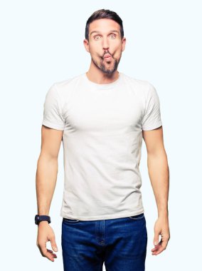 Casual beyaz t-shirt yapma balık yüz dudaklı, çılgın ve komik bir jest giyen yakışıklı adam. Komik ifade.
