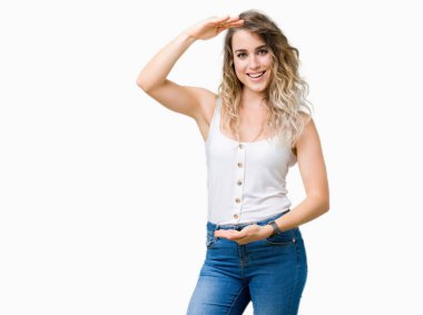 İzole arka plan ile büyük ve büyük boy işaret, ölçü birimi sembol gösteren el eller genç güzel sarışın kadın. Kameraya bakarak gülümsüyordu. Ölçüm kavramı.