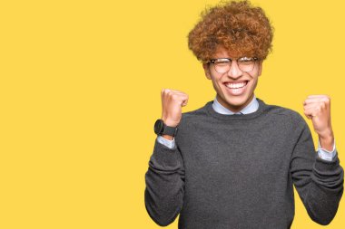 Silah ile şaşırmış ve hayret için başarı kutluyor gözlük takan afro saçlı genç yakışıklı iş adamı kaldırdı ve gözleri açık. Kazanan kavramı.