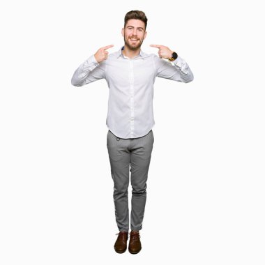 Kendinden emin gösterilen ve işaret parmakları diş ve ağız ile gülümseyen genç yakışıklı iş adamı. Sağlık kavramı.