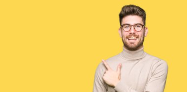 Neşeli bir gülümseme ile el ve parmak kadar yan yüzünde mutlu ve doğal ifade ile işaret yüz ile gözlüklü genç yakışıklı iş adamı