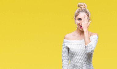 El yüz ve sürpriz duygu kendinden emin gülümseme ile tek gözüyle kapsayan izole arka plan genç güzel sarışın ve mavi gözlü kadın.