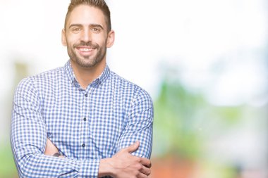 İzole arka plan mutlu yüz çapraz silah kameraya bakarak ile gülümseyen genç yakışıklı adam. Olumlu bir kişi.