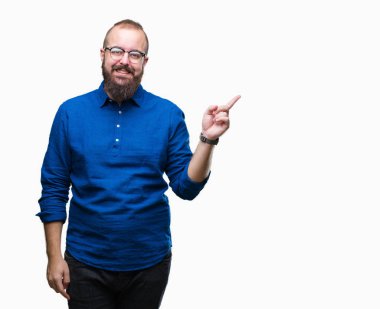 Yüzünde kocaman bir gülümseme ile izole arka plan üzerinde gözlük takan Genç beyaz hipster adam kameraya bakarak yan el ve parmak ile işaret.