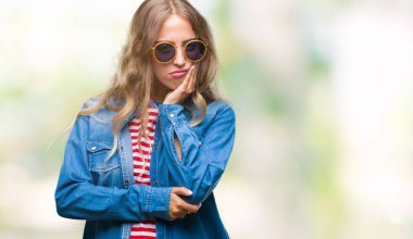 Güzel genç sarışın kadın seyir yorgun ve bıkkın ile depresyon sorun Çapraz kollar ile izole arka plan düşünme üzerinde güneş gözlüğü takıyor.