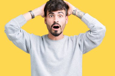 Genç yakışıklı adam giyen kazak üzerinde arka plan deli izole ve baş, korkuyor ve açık ağzı ile şok sürpriz elleriyle korkuttu