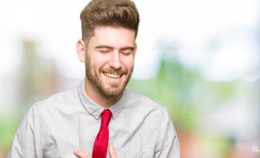 Genç yakışıklı iş dostum gülen ve komik deli şaka çünkü yüksek sesle zor gülüyor. Mutlu ifade.