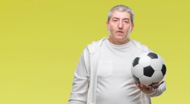Üst düzey yakışıklı acımak yüz ciddi düşünüyorum üstünde kendine güvenen bir ifade ile izole arka plan üzerinde futbol futbol topu tutan