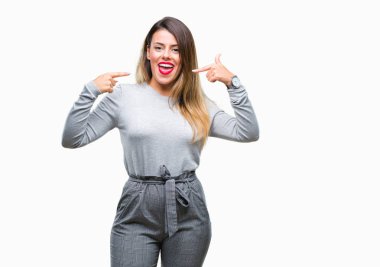 Genç güzel işçi iş kadını kendine güvenen gösterilen ve işaret parmakları diş ve ağız ile gülümseyen izole arka plan üzerinde. Sağlık kavramı.