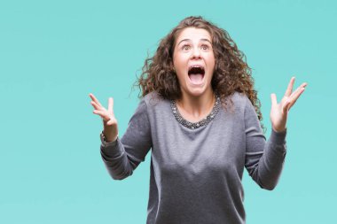 Kızgın ve silah ile başarı için deli kutluyor izole arka plan üzerinde bir kazak giyen genç kız kaldırdı ve heyecanlı çığlık gözleri kapalı güzel esmer kıvırcık saçlı. Kazanan kavramı