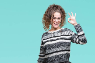 Güzel esmer kıvırcık saçlı Genç kız izole arka plan el ve parmaklar ok işaretiyle yapıyor olumlu gülümseyen üzerinde gözlük takıyorum. Başarılı ifade.