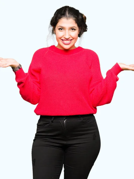 お団子笑顔表示や赤いセーターを着ている若い美しい女性の手オープン手のひら 表示や広告を比較してバランス — ストック写真