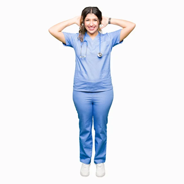アダルト女医女性医療制服リラックスとストレッチを身に着けている腕と頭と首の後ろに手 幸せな笑みを浮かべて — ストック写真