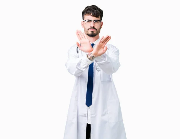 若い医者分離背景除去式交差腕と手のひらの負の符号 怒った顔をして病院のコートを着た男 — ストック写真