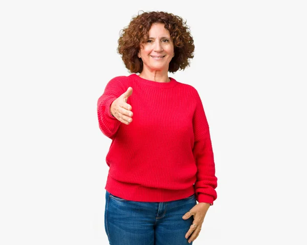 美しい中間エイガー年配の女性赤冬セーターの上は 笑みを浮かべて挨拶と歓迎フレンドリーな提供するハンドシェイクの背景を隔離しました ビジネスの成功 — ストック写真