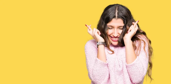 Mujer Hermosa Joven Con Suéter Rosa Sonriendo Cruzando Los Dedos — Foto de Stock