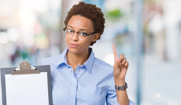 Jovem Afro Americana Empresária Segurando Prancheta Sobre Fundo Isolado Surpreso — Fotografia de Stock