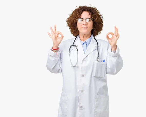 中年资深医生妇女在孤立的背景放松和微笑与眼睛闭着眼睛用手指做冥想手势 瑜伽概念 — 图库照片