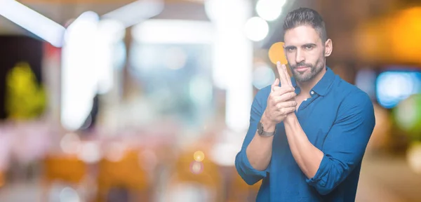 Joven Hombre Guapo Sobre Fondo Aislado Sosteniendo Arma Simbólica Con — Foto de Stock