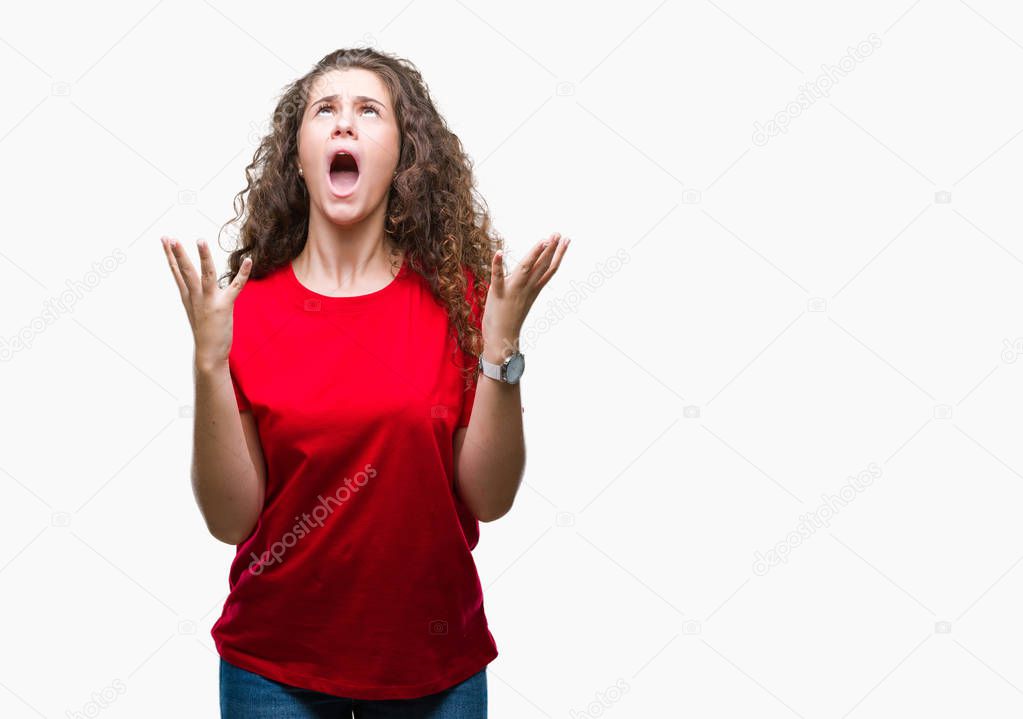 Beautiful brunette curly hair young girl wearing casual look over isolated background crazy and mad shouting and yelling with aggressive expression and arms raised. Frustration concept.