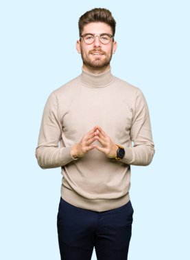 Gözlüklü eller birlikte genç yakışıklı iş adamı ve parmakları rahat ve neşeli gülümseyen geçti. Başarı ve iyimser