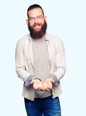 Genç sarışın adamın giydiğini gülen alma veya jest vererek birlikte el avuç içi ile gözlük. Ayrı tutma ve koruma