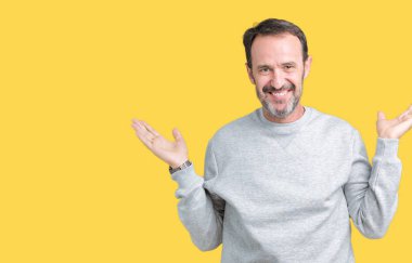 Gülen iki elle gösterilen açık avuç içi, sunma ve karşılaştırma ve denge reklam arka plan üzerinde bir kazak giymiş yakışıklı orta yaş komuta sizde izole