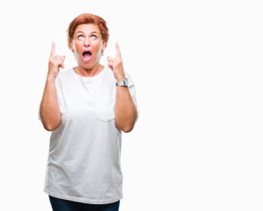 Atrractive üst düzey beyaz Kızıl saçlı kadın izole arka plan üzerinden hayran ve yukarıya bakıp parmakları ile işaret şaşırttı ve silah kaldırdı.