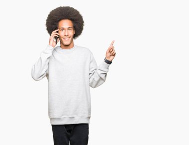 Smartphone'da el ve parmak ile tarafına işaret çok mutlu konuşmaya afro saçlı genç Afro-Amerikan adam