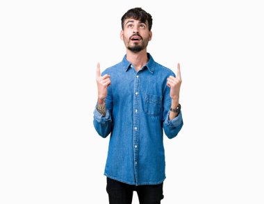 Yakışıklı delikanlı izole arka plan üzerinden hayran ve yukarıya bakıp parmakları ile işaret şaşırttı ve silah kaldırdı.