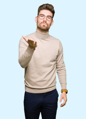 Bir öpücük el ile güzel ve seksi olmak hava üfleme kamera bakarak gözlüklü genç yakışıklı iş adamı. Aşk ifade.