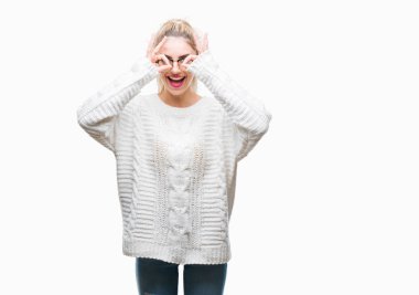 Dilini, parmaklarının arasından baktığını yapışmasını dürbün gibi ok jest yapıyor izole arka plan üzerinde gözlük takan genç güzel sarışın bir kadın. Deli ifade.