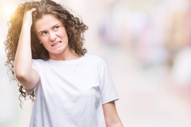 Güzel esmer kıvırcık saçlı Genç kız giyiyor rahat t-shirt izole arka plan üzerine yanıltır ve soru hakkında merak ediyorum. Şüphe, kafasına el ile düşünme ile belirsiz. Dalgın kavramı.