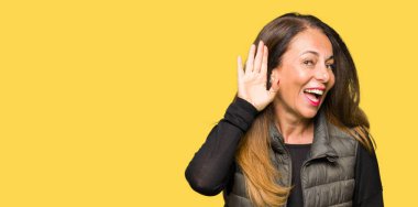 Güzel Orta Çağ kadın, kulak üzerine el ile gülümseyen kış yelek giyen söylenti veya dedikodu için bir işitme dinlerken. Sağırlık konsepti.