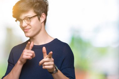 Fotoğraf makinesi ile mutlu ve komik yüz için parmakları işaret izole arka plan üzerinde gözlük takan yakışıklı delikanlı. İyi enerji ve vibes.