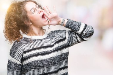 Güzel esmer kıvırcık saçlı Genç kız bağırarak ve ağzı üzerinde el ile yan için çığlık izole arka plan üzerinde gözlük takıyorum. İletişim kavramı.