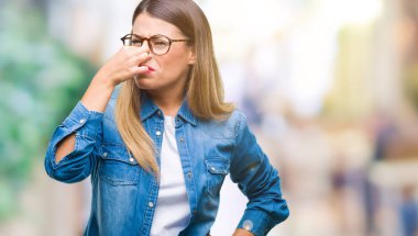 Gözlük takan bir şey pis ve iğrenç kokulu izole arka plan, dayanılmaz koku, holding nefes burun parmaklar ile üzerinde genç güzel kadın. Kötü kokuyor kavramı.