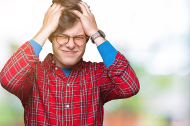 Çünkü çaresiz ve stresli baş ağrısı acı izole arka plan üzerinde gözlüklü genç yakışıklı adam ağrı ve migren. Ellerini kafasına.