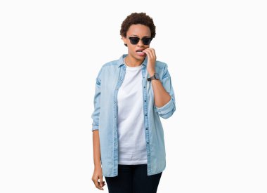 Tırnak ısırma dudaklarından eller güzel genç Afro-Amerikan kadın stresli ve gergin ile izole arka plan üzerinde güneş gözlüğü takıyor. Anksiyete sorunu.