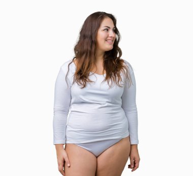 Artı boyutu genç overwight kadın güzel üzerinde beyaz iç çamaşırı giyiyor arka plan görünümlü yan ve dik dik bakma uzağa düşünce gülümseyen izole.