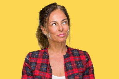 Orta yaş yetişkin kadın görünümlü yan ve dik dik bakma uzağa düşünce gülümseyen izole arka plan üzerinde rahat ceket.