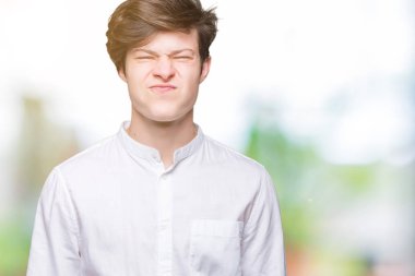 Komik surat ile yanakları şişirme izole arka plan üzerinde genç yakışıklı iş adamı. Ağız ile hava, deli ifade şişirilmiş.