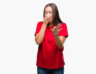 Genç güzel beyaz bir kadın bir şey pis ve iğrenç kokulu izole arka plan, dayanılmaz koku, holding nefes burun parmaklar ile. Kötü kokuyor kavramı.