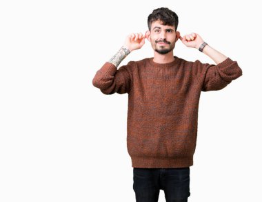 Üzerinde kış kazak giyen genç yakışıklı adam arka plan gülen çekerek kulakları parmaklar, komik jest ile izole. Seçmelere sorun